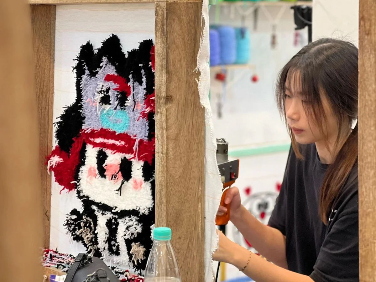 A customer tufting her rug with a tufting gun